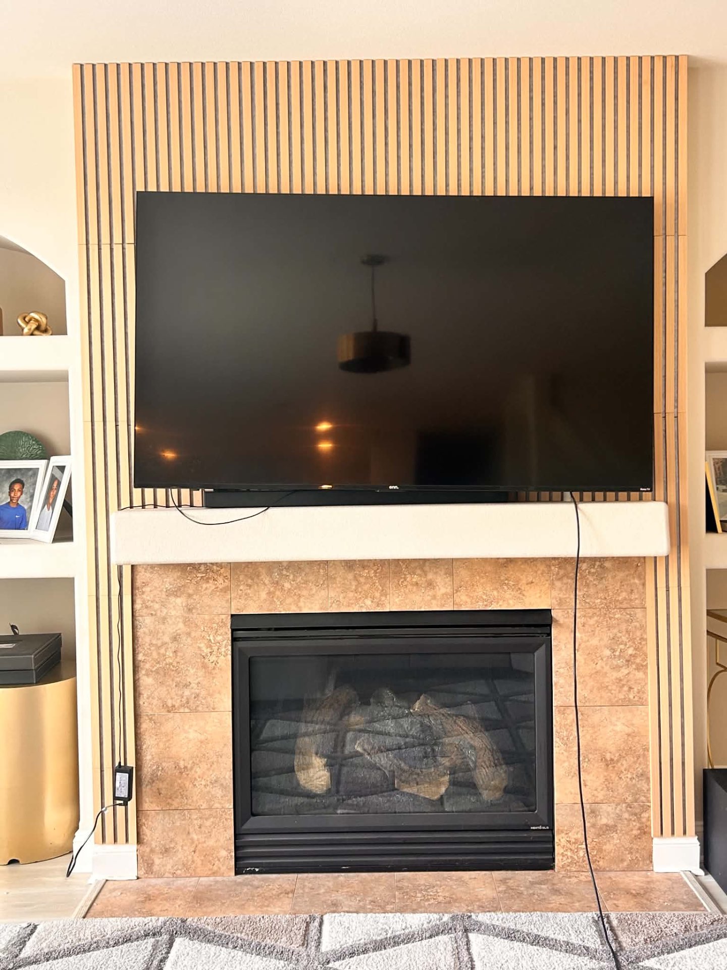 Finished fireplace feature wall with wood slat paneling and mounted TV