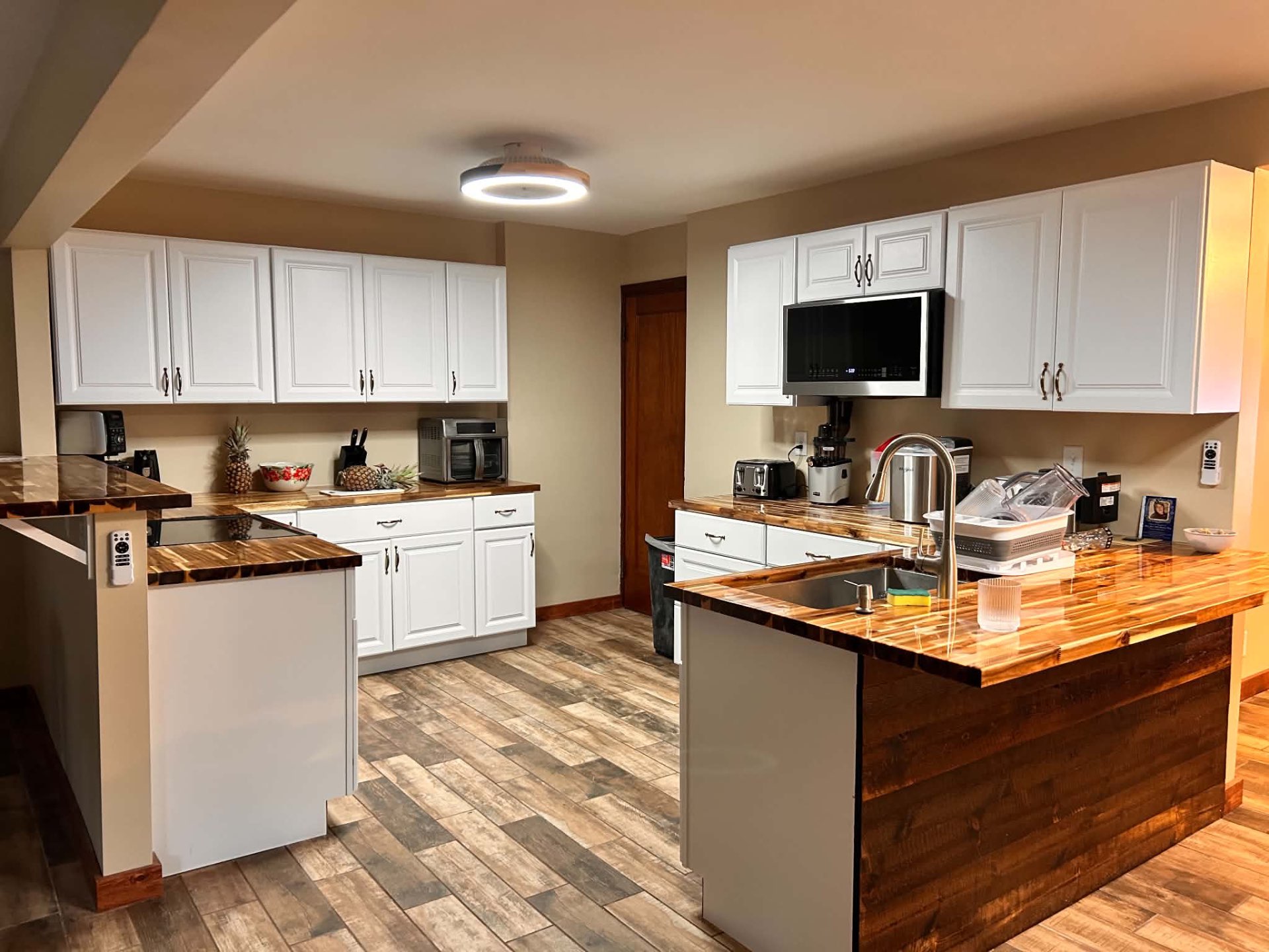 Finished kitchen remodel with white cabinetry and wood countertops by Reyna's Remodeling